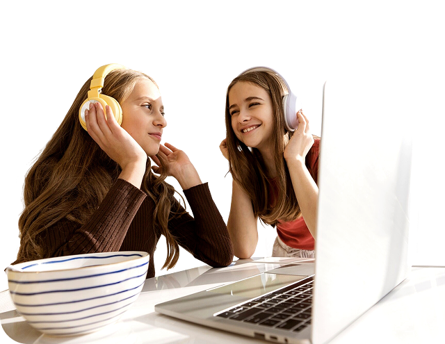 two young women listening to headphones while at a laptop